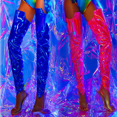A rave girl wearing blue holographic leg covers and another rave girl wearing pink holographic leg covers to a rave.