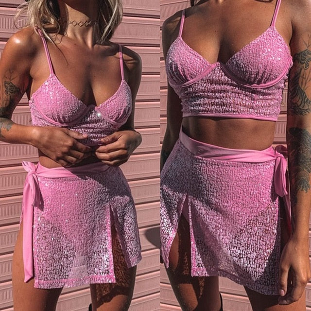 A rave girl wearing pink sequin crop top and skirt.