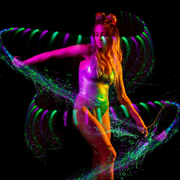 A woman dancing with LED colo chranging fiber optic whip for raves.