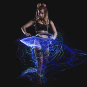 A woman dancing with trippy and LED color changing fiber optic whip for raves.
