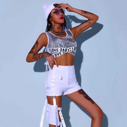 A girl wearing white sequin rave crop top and black shorts with cap wig.