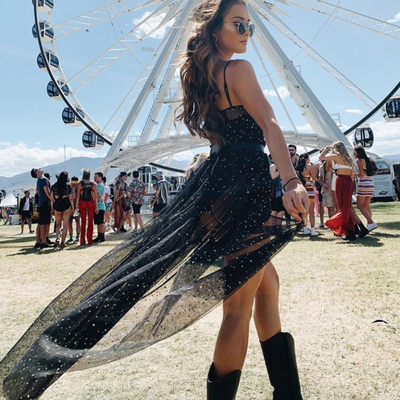 A rave girl wearing starry mesh blac dress at a music festival.