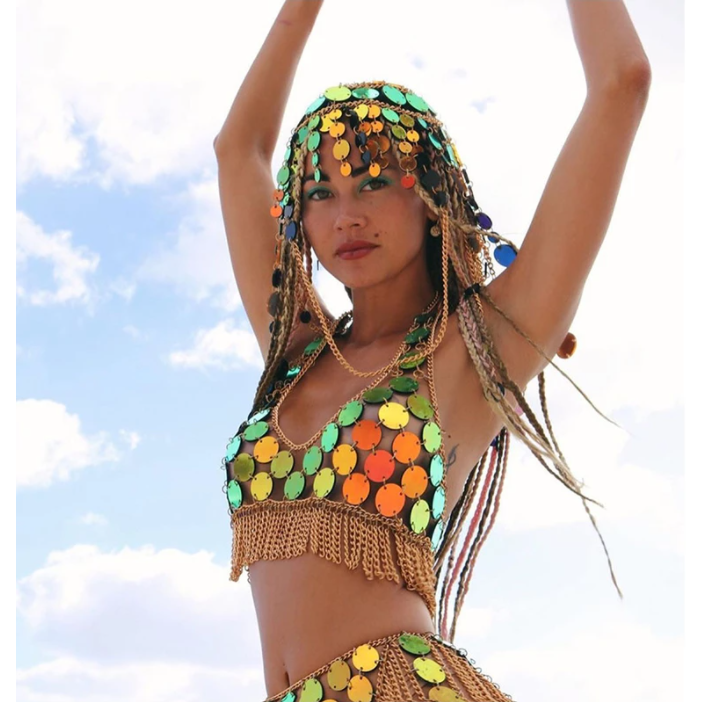 A woman wearing adjustable sequin crop top and tassel skirt to a rave or music festival.