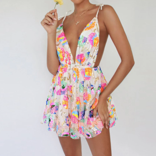 A rave girl wearing sleeveless foral sequin dress to a rave or music festival.