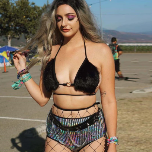 A woman wearing fluufy fur black bra for raves at a music festival.