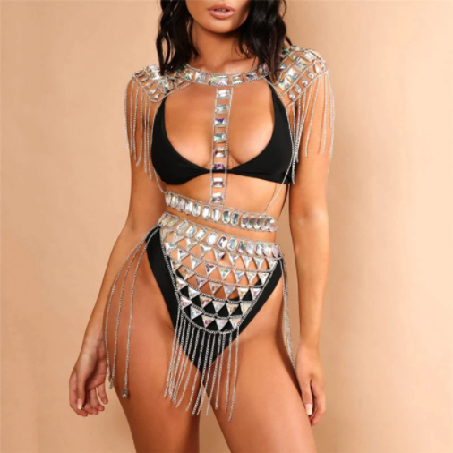 A rave girl wearing silver rhinestone two piece set with tassels at a music festival.