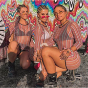 Three rave girls wearing colorful sheer mesh dress at a music festival.