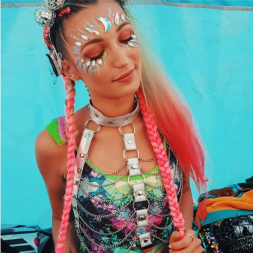 a rave girl with face jewels wearing chain harness rave crop top