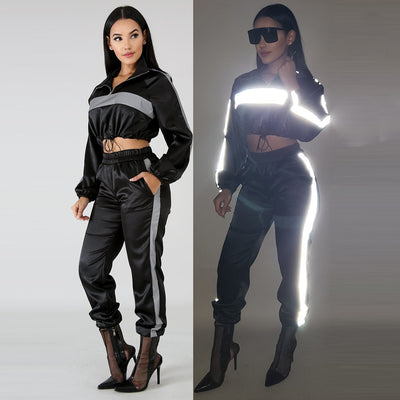 A rave girl wearing reflective crop jacket and reflective pants to a rave or music festival.